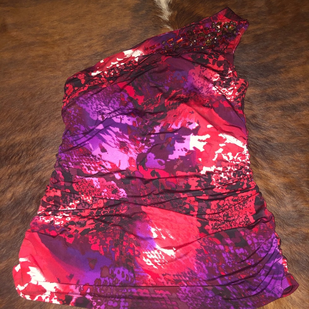 Asymmetrical top adorned with jewels.